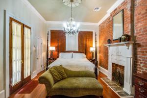 um quarto com uma cama, uma cadeira e uma lareira em New Orleans Jazz Quarters em Nova Orleans