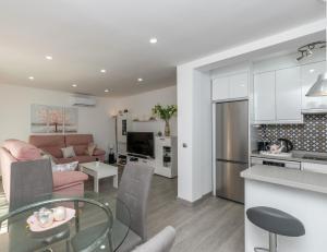 a kitchen and living room with a glass table at New Modern 3BR with terrace in Fuengirola Centre in Fuengirola