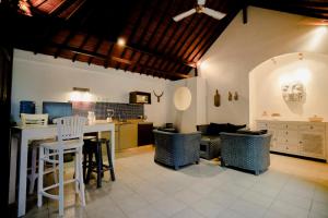uma cozinha e sala de estar com mesa e cadeiras em Villa Dewi em Seminyak