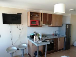 a small kitchen with a counter and a microwave at Depto Estudio 1811 Edificio Centro Blanco con estacionamiento in Temuco