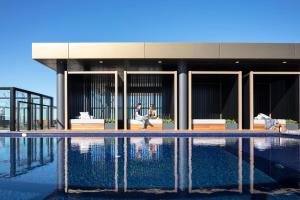 a man and woman sitting on a bench next to a swimming pool at Wentworth Point Oversized balcony view apartment in Sydney