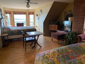 sala de estar con cama y mesa con TV en Harbor House Hotel by Umaniii in Jonesport Maine, en Jonesport