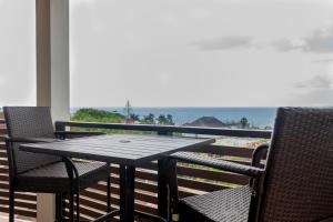 a table and chairs on a balcony with a view of the ocean at A Wave From It All @ Aqueducts in Negril