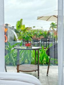 a table with chairs and an umbrella on a patio at Hoi An Cabbage Garden in Hoi An