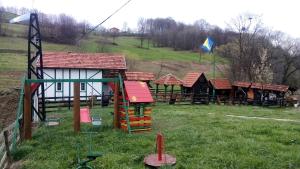 a group of wooden play structures in a field at Apartman Bosanska Avlija-Muzej- in Visoko +10 photos
