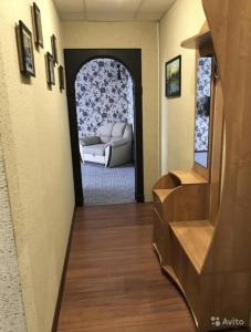 a living room with a couch through a doorway at Ugra apartment 36 in Kogalym