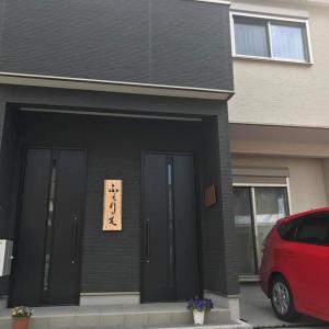 Ferie Nara في نارا: منزل أسود مع باب عليه علامة