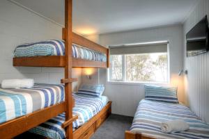 two bunk beds in a room with a window at 10 Maisonettes in Falls Creek