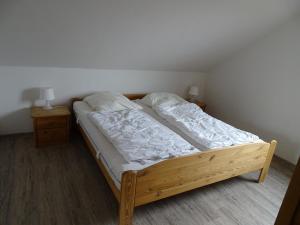 een bed in een slaapkamer met 2 nachtkastjes en 2 tafels bij Ferienhaus Ostseeblick in Hohen Schönberg