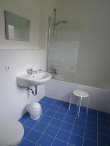 a bathroom with a sink and a tub and a stool at Ferienhaus Ostseeblick in Hohen Schönberg