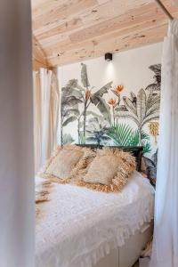 een slaapkamer met een hemelbed met planten aan de muur bij Dream house Esveld in Terschuur