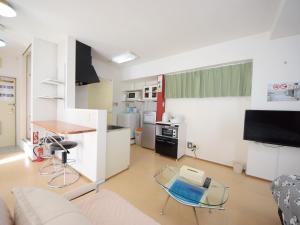sala de estar con sofá y cocina en STAY IN SUMUKA Shintoshin, en Naha