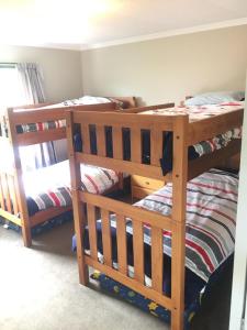 a room with three bunk beds in a room at Terrific house on totara drive in Twizel