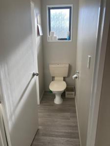 a bathroom with a toilet and a window at Terrific house on totara drive in Twizel