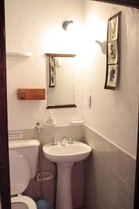 a bathroom with a sink and a toilet and a mirror at Hosteria La Estacion in Tilcara