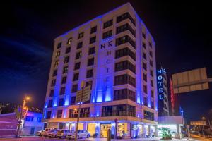 duży budynek z niebieskimi światłami w nocy w obiekcie NK Hotel w mieście Izmir