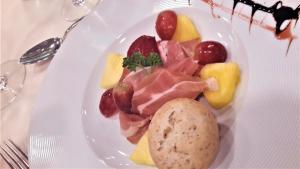 a plate of food with meat and fruit on a table at Penzión Pod orechom in Turčianske Teplice