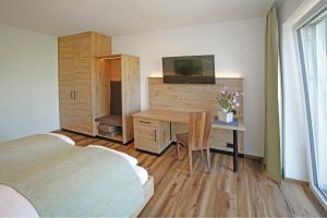 a bedroom with a desk and a bedroom with a bed and a television at Gasthof Berger in Sankt Peter