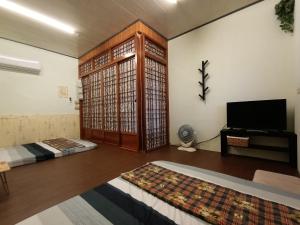 a room with two beds and a flat screen tv at 綠島山仔腳民宿 Ludao B&B in Green Island