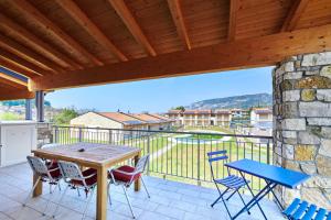 eine Terrasse mit einem Tisch und Stühlen auf dem Balkon in der Unterkunft ApartmentsGarda - Garda31 Residence in Garda