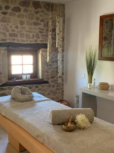 a bedroom with a bed with a stone wall at DOMAINE DE LA RESERVE in Coublanc