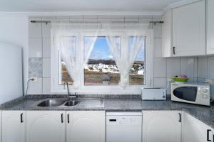 une cuisine avec un évier et une fenêtre dans l'établissement Casa Salinas del Mar, à Guatiza