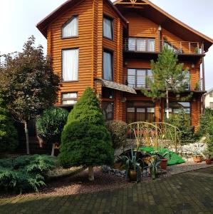 ein Holzhaus mit einem Garten davor in der Unterkunft Luxury apartments with pool and sauna in the Villa in Czernowitz