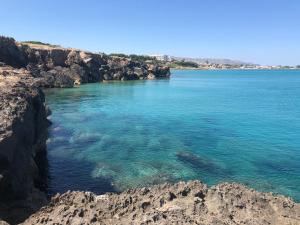 a large body of water next to some rocks at O'scià Loft in Noto