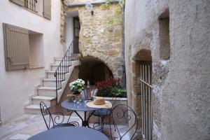 a patio with a table and chairs in a building at LE PASSAGE in Lourmarin