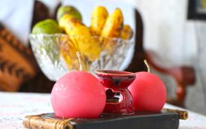 un bol de fruta y una taza roja sobre una mesa en Saria Self Catering en Praslin