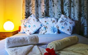 a bed with blue and white pillows on it at Saria Self Catering in Praslin