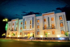 a large white building at night at EmirHan Hotel in Samarkand