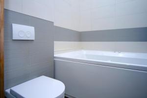 a bathroom with a tub and a toilet and a sink at Summit Apartments in Kyiv