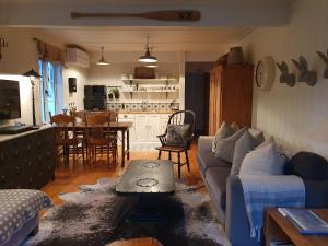 a living room with a couch and a table at Gibbston Boathouse with Outdoor Bath in Gibbston