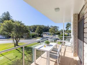 a balcony with a white table and chairs on it at Villa Ellisa 4 beautiful unit with beautiful water views at Little Beach in Nelson Bay