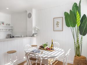 cocina blanca con mesa y sillas en Villa Ellisa 4 beautiful unit with beautiful water views at Little Beach, en Nelson Bay