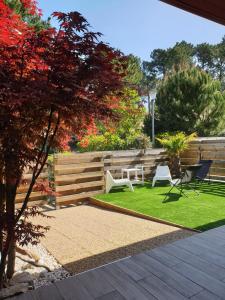 a garden with two chairs and a table on grass at Blue Ocean in Moliets-et-Maa