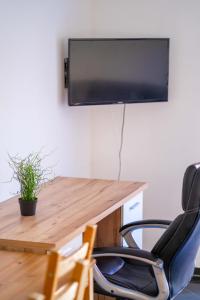 an office with a desk with a television on a wall at SUNNYHOME Monteurwohnungen und Apartments nahe Regensburg in Obertraubling