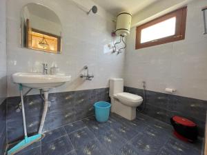 a bathroom with a sink and a toilet and a mirror at La Voglia-Old Manali in Manāli