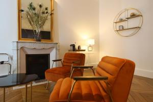 a living room with two chairs and a fireplace at DEMEURE DES CORDELIERS avec parking privé in Blois