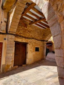 un antiguo edificio de piedra con puerta de madera en Les Voltes, en Barbará