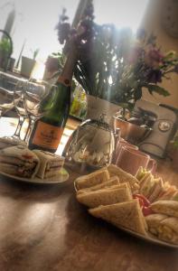 a table with two plates of sandwiches and a bottle of wine at Westbourne Lodge in Birmingham