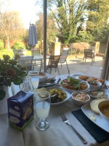 einen Tisch mit Teller mit Lebensmitteln und Gläsern Milch in der Unterkunft Westbourne Lodge in Birmingham