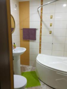 a bathroom with a sink and a tub and a toilet at Аpartments on the main street in Bălţi