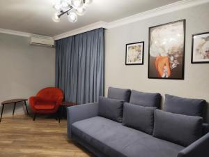 a living room with a couch and a red chair at Apartment on Bohdana Havrylyshyna in Kyiv