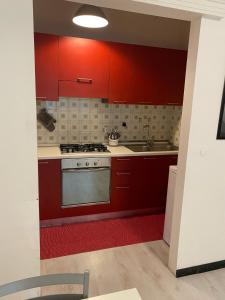 a kitchen with red cabinets and a stove at Appartamento al Duomo in Padova