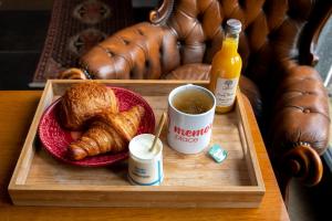 ein Tablett mit einem Teller Croissants und einer Tasse Kaffee in der Unterkunft Le duplex d'André - Un écrin cosy et design pour 2 in Lyon