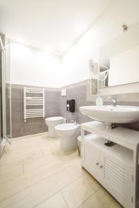 Un baño blanco con lavabo e inodoro. en Ostia Holiday Al 138, en Lido di Ostia