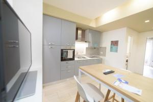 Una cocina con una mesa de madera y un comedor. en Ostia Holiday Al 138, en Lido di Ostia 4 fotos más
