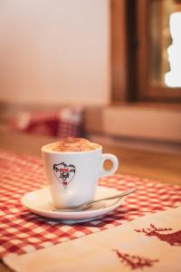 una tazza di caffè su un piatto su un tavolo di Berghotel Gaffia a Wangs